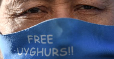 A member of the Uyghur minority wears a face mask to protect against the spread of the coronavirus as they demonstrate near China's consulate in Istanbul, Turkey, Feb. 22, 2021. (AFP Photo)