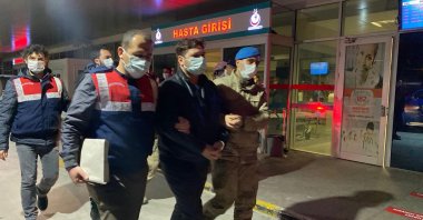 Gendarmerie officers escort a suspect for a medical check after his detention, in Izmir, western Turkey, March 23, 2021. (Anadolu Agency)