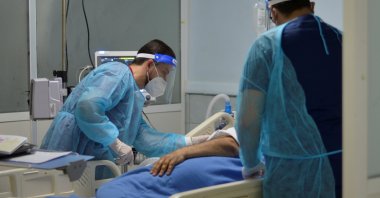 Medical staff members assist a patient suffering from coronavirus disease (COVID-19), in an intensive care unit at a hospital in Amman, Jordan, March 23, 2021.  (REUTERS/Muath Freij)