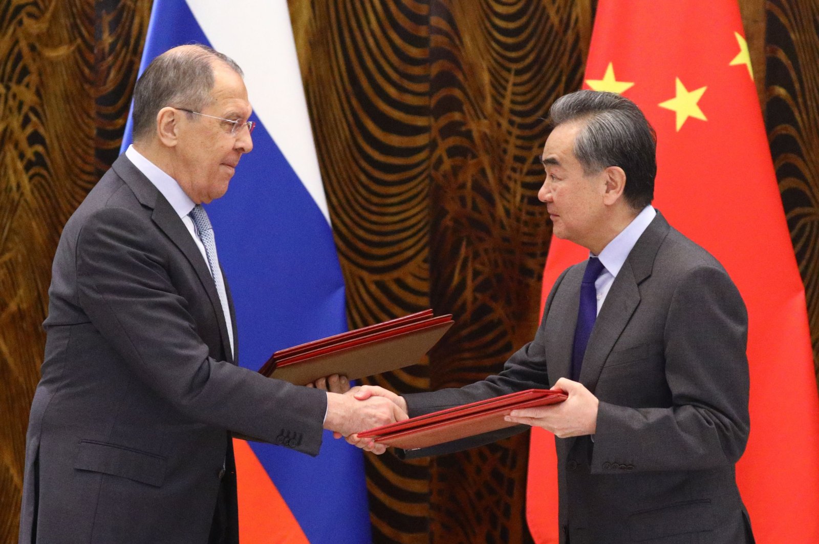Russian Foreign Minister Sergei Lavrov (L) and Chinese Foreign Minister Wang Yi exchange documents during a signing ceremony following their talks in Guilin, China, March 23, 2021. (Russian Foreign Ministry via AFP)