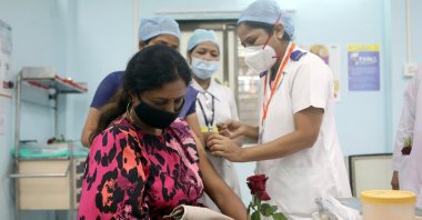 A health care worker holding a rose receives AstraZeneca's COVISHIELD vaccine at a medical center during the coronavirus vaccination campaign, Mumbai, India, Jan. 16, 2021. (Reuters Photo)