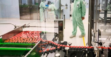 A laboratory technician supervises capped vials during filling and packaging tests for the large-scale production and supply of AstraZeneca’s COVID-19 vaccine, at a biologics’ manufacturing facility in Anagni, Italy, Sept. 11, 2020. (AFP Photo)