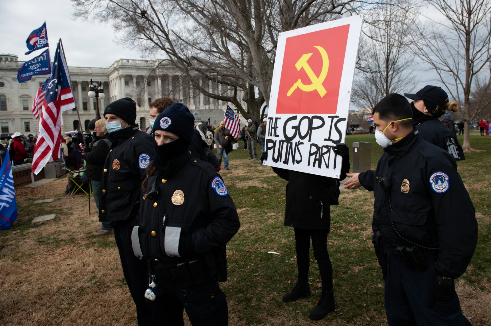 U.S. Capitol police officers surround a demonstrator holding a sign reading "The GOP Is Putin's Party" during a protest outside of the U.S. Capitol, Washington, D.C., U.S., Jan. 6, 2021. (Photo by Getty Images)