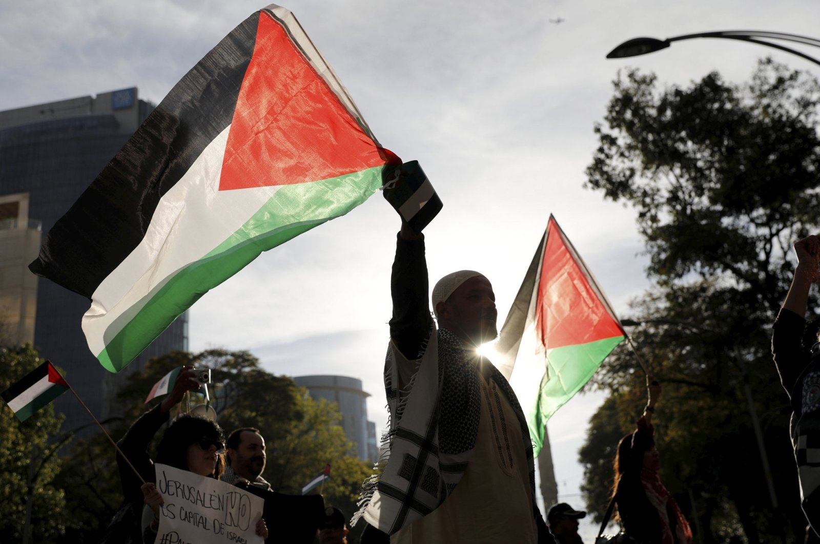 A man holds a Palestinian flag next to supporters of Palestine while demonstrating against U.S. President Donald Trump's recognition of Jerusalem as Israel's capital, outside the U.S embassy in Mexico City, Mexico, Dec. 25, 2017. (Reuters Photo)