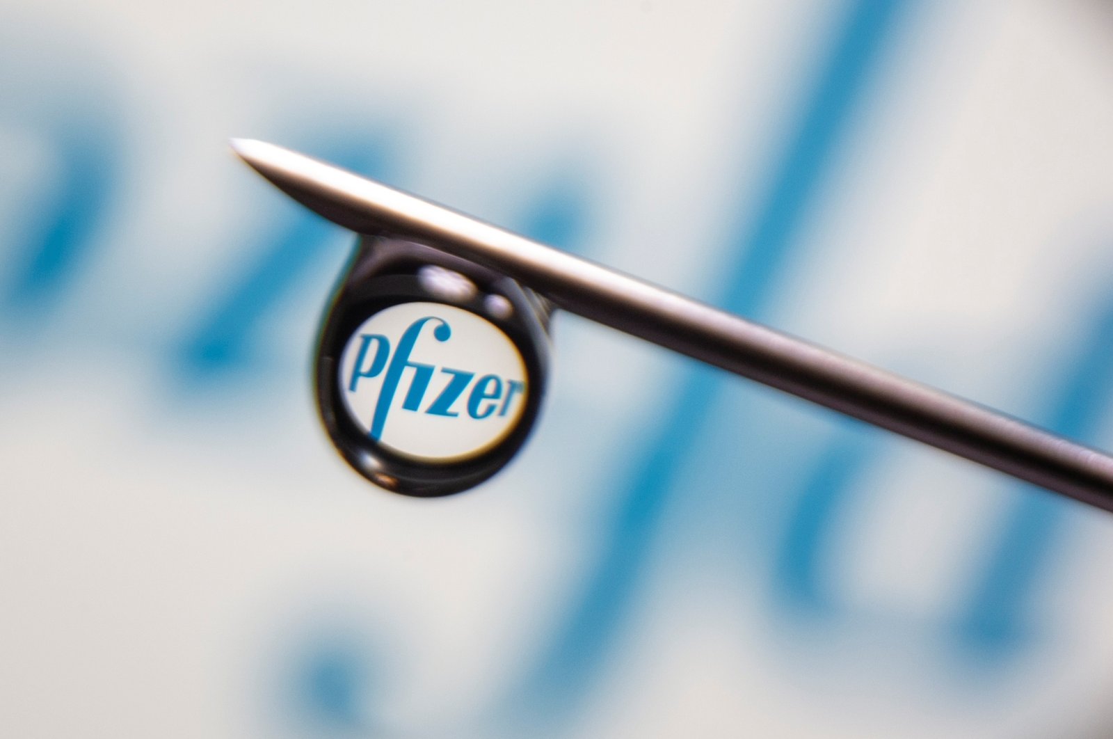 The Pfizer logo is reflected in a drop on a syringe needle in this illustration photo taken March 16, 2021. (REUTERS Photo)