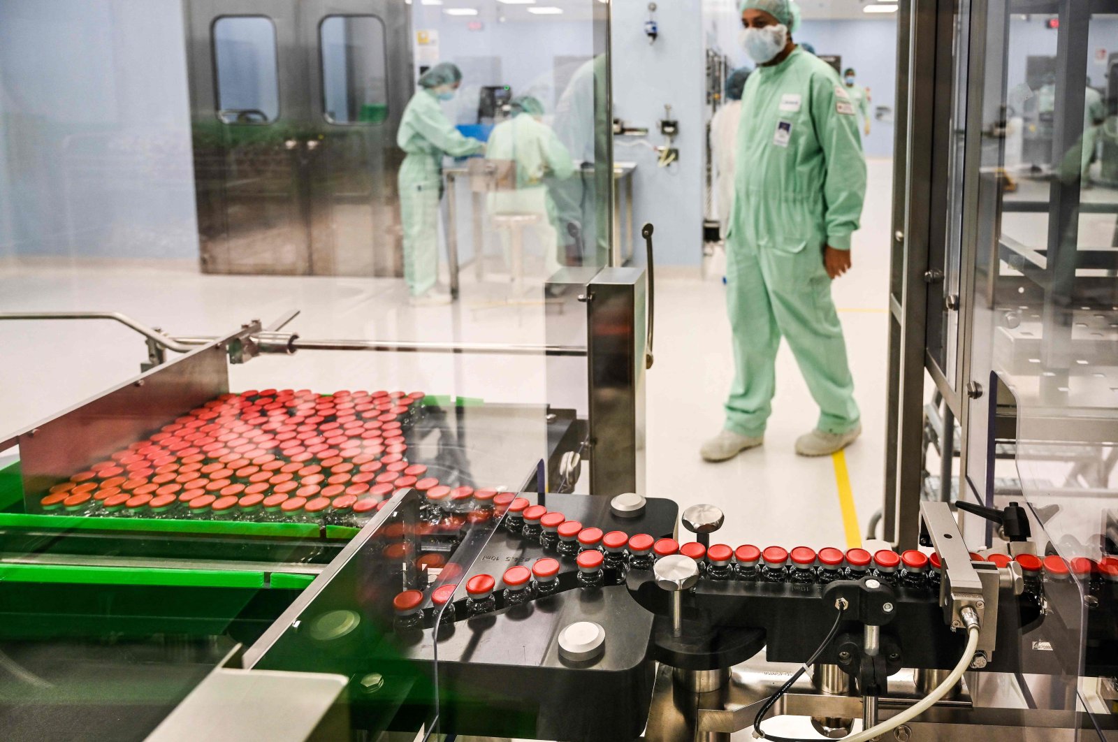 A laboratory technician supervises capped vials during filling and packaging tests for the large-scale production and supply of AstraZeneca’s COVID-19 vaccine, at a biologics’ manufacturing facility in Anagni, Italy, Sept. 11, 2020. (AFP Photo)