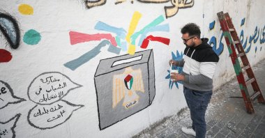 A Palestinian artist paints graffiti on a wall in the Gaza Strip to draw attention to the importance of voting in the Palestinian Legislative Council elections scheduled for May 22, Gaza, Palestine, March 24, 2021. (AA Photo)