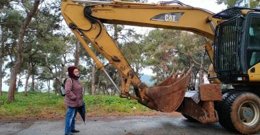 An activist stands in front of a bulldozer preparing to demolish a stable, Heybeliada, Istanbul, Turkey, March 25, 2021. (DHA PHOTO)