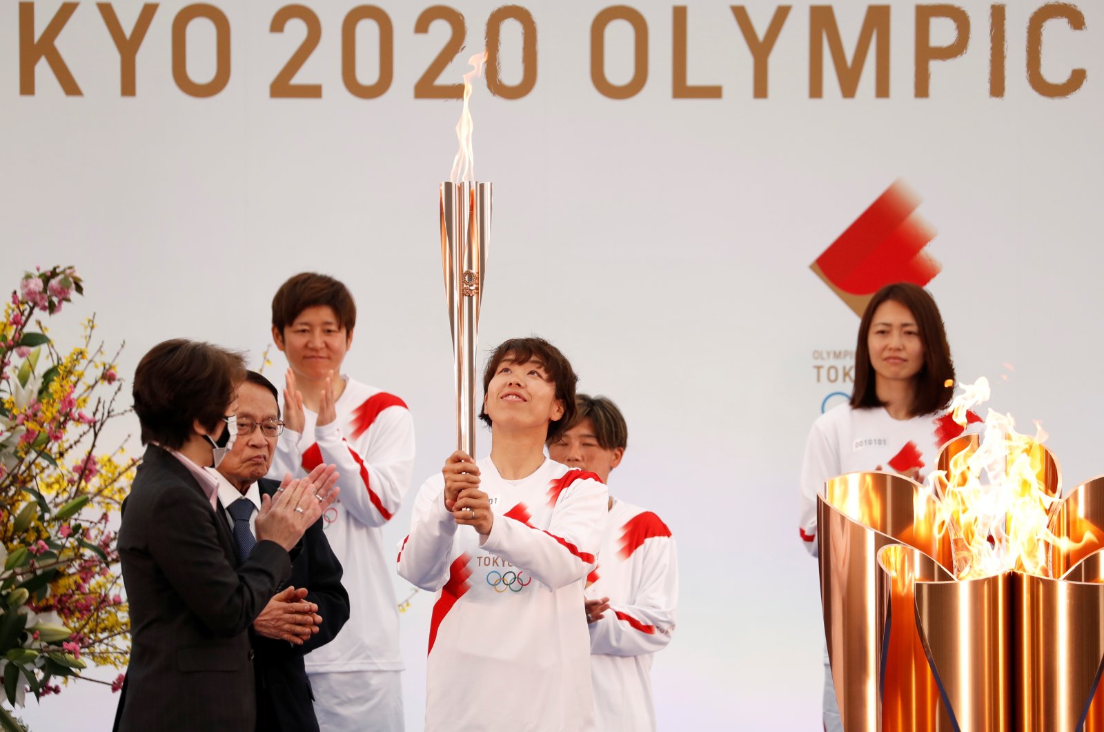 A member of Japan's women's national football team carries the torch during the Tokyo 2020 Olympic Torch Relay Grand Start in Naraha, Japan, March 25, 2021. (Reuters Photo)