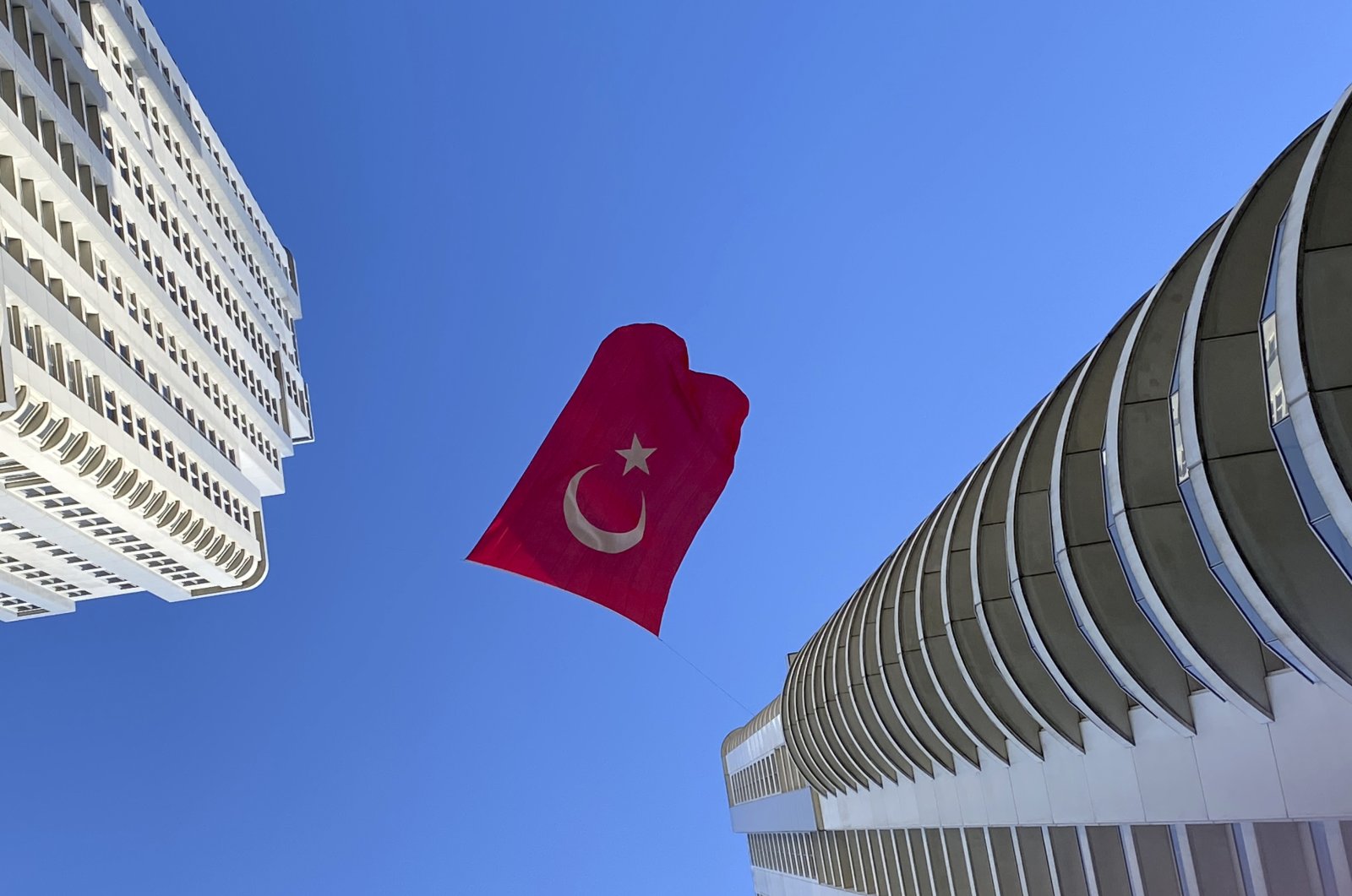 A Turkish flag suspended between two skyscrapers flutters in the wind, in Istanbul, Turkey, April 23, 2020. (AP Photo)