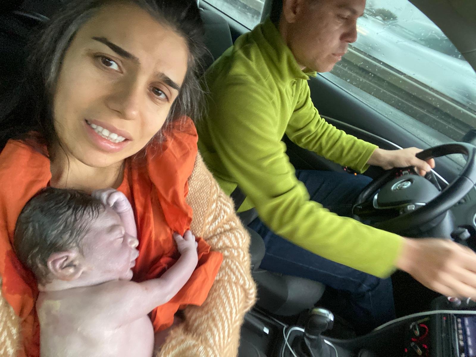 Mother Seda Giray (L) poses for a selfie with her newborn son Devin Ege as her husband Deniz drives to the hospital, in Istanbul, Turkey, March 24, 2021. (DHA Photo)