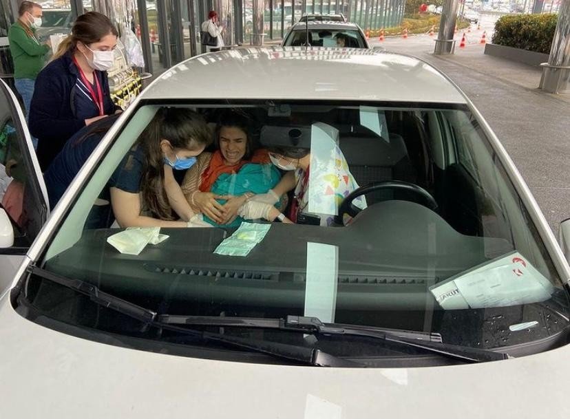 Nurses tend to mother Seda Giray (R) and her newborn baby Devin Ege inside their vehicle at the entrance of a private hospital in Istanbul, Turkey, March 24, 2021. (IHA Photo)