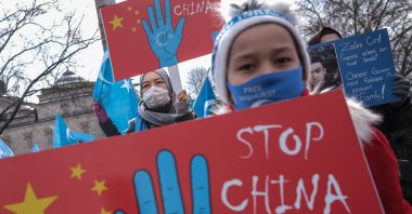 Uyghur protestors who have not heard from their families living in East Turkestan hold placards and Uyghur flags during a protest against China, in Istanbul, Turkey, March 25, 2021. (EPA Photo)