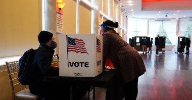 A poll worker talks to a voter before they vote on a paper ballot on Election Day in Atlanta, Georgia, Nov. 3, 2020. (AP Photo)