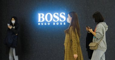People walk past a store of German fashion house Hugo Boss in Beijing, China, March 27, 2021. (Reuters Photo)