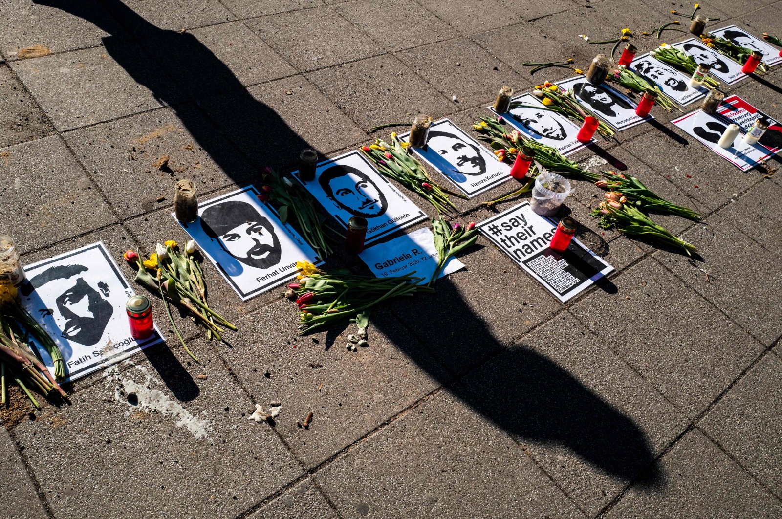 A passer-by casts a shadow on a makeshift memorial commemorating the nine victims of the deadly 2020 Hanau terrorist attack in front of a shopping mall in Berlin, Germany, March 2, 2021. (AFP Photo)