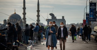 People in masks walk past fishermen during the COVID-19 pandemic, Istanbul, Turkey, Dec. 29, 2020. (Shutterstock Photo)