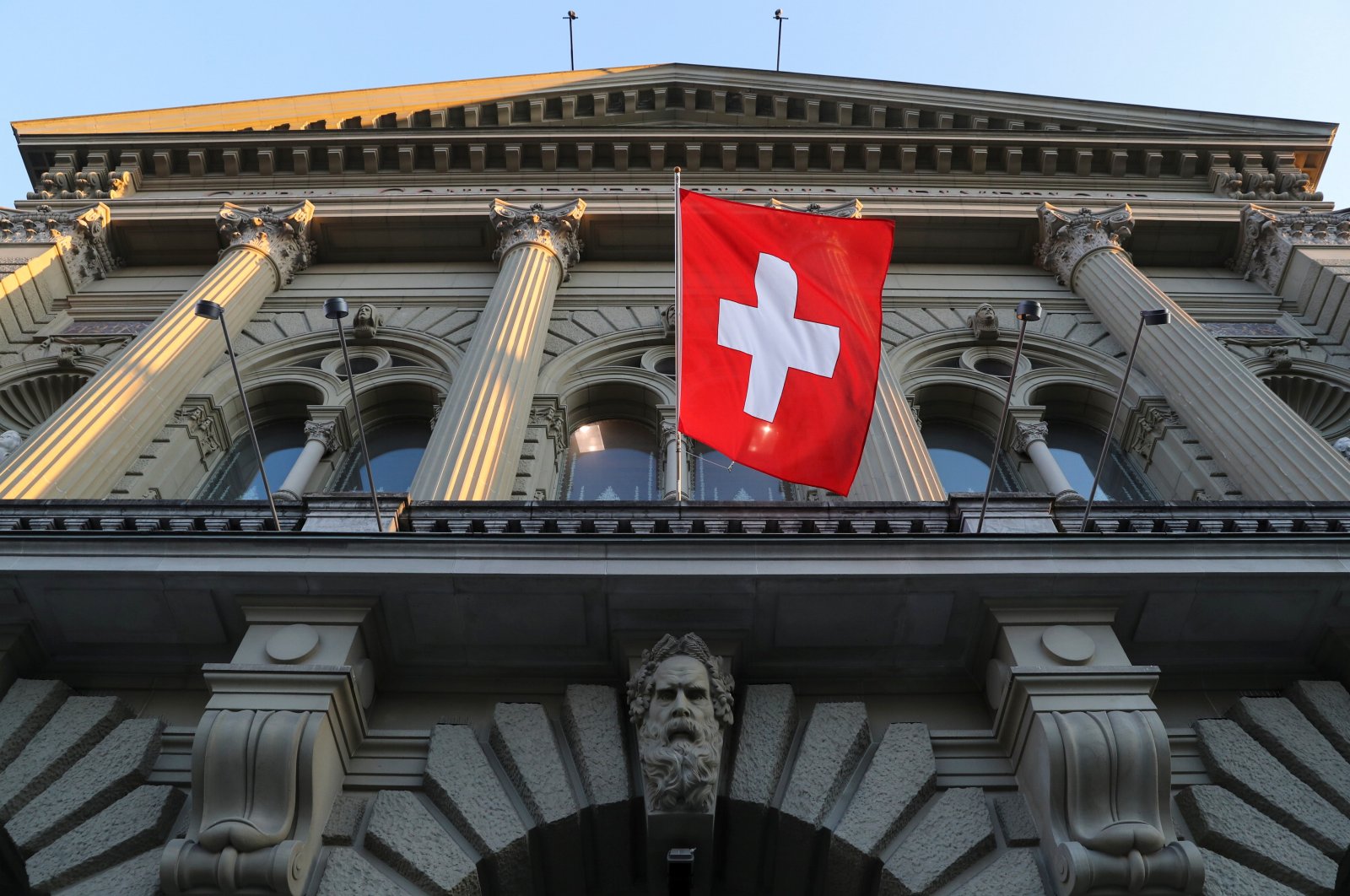 Switzerland's national flag flies at the Swiss Federal Palace (Bundeshaus), the seat of the parliament and the government, in Bern, Switzerland, March 18, 2021. (Reuters Photo)