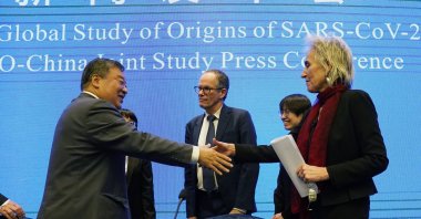 Marion Koopmans (R) and Peter Ben Embarek (C) of the World Health Organization team say farewell to their Chinese counterpart Liang Wannian after a WHO-China Joint Study Press Conference at the end of the WHO mission in Wuhan, China, Feb. 9, 2021. (AP Photo)