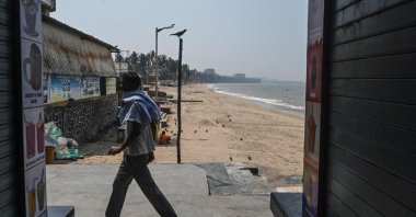 A shopkeeper walks past shuttered shops following restrictions during the Hindu festival of Holi amid rising COVID-19 cases, at the food plaza on Juhu Chowpatty beach, Mumbai, India, March 29, 2021. (AFP Photo)