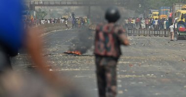 Border Guards Bangladesh (BGB) personnel stand guard as activists from Hefazat-e-Islam, seen at a distance, block a road during a nationwide strike following deadly clashes with police over Indian Prime Minister Narendra Modi’s visit, in Narayanganj, about 16 km southeast of Dhaka, March 28, 2021. (AFP Photo)