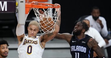 Los Angeles Lakers forward Kyle Kuzma (L) dunks past Orlando Magic forward James Ennis III during an NBA game, Los Angeles, California, U.S., March 28, 2021. (AP Photo)