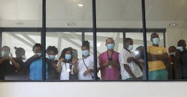 Health care workers look through a window at a hospital during the rollout of the first batch of Johnson and Johnson vaccines in the country, in Khayelitsha, Cape Town, South Africa, Feb. 17, 2021. (AP Photo)