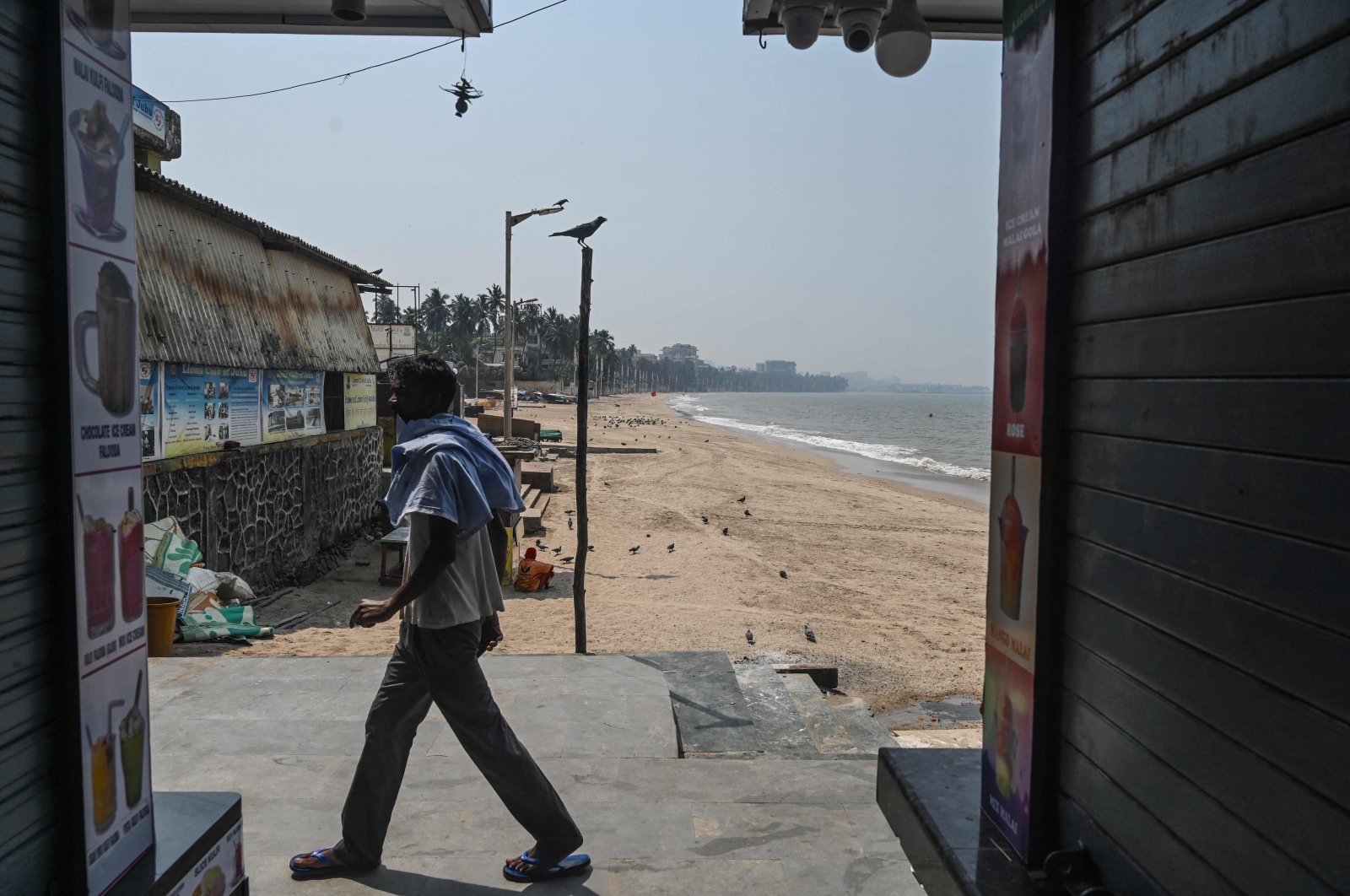 A shopkeeper walks past shuttered shops following restrictions during the Hindu festival of Holi amid rising COVID-19 cases, at the food plaza on Juhu Chowpatty beach, Mumbai, India, March 29, 2021. (AFP Photo)