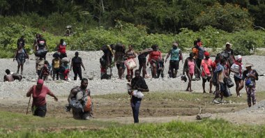 Migrants cross the Tuquesa river after a trip on foot through the jungle to Bajo Chiquito, Darien Province, Panama, on Feb. 10, 2021. (AP Photo)