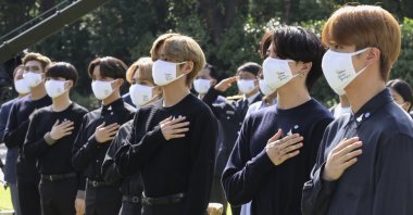 South Korean K-pop group BTS salutes their national flag during a ceremony marking the National Youth Day at the presidential Blue House in Seoul, South Korea, Sept. 19, 2020. (AP Photo)