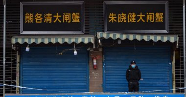 A security guard stands outside the Huanan Seafood Wholesale Market where the coronavirus was detected in Wuhan, China, Jan. 24, 2020. (Photo by Hector RETAMAL / AFP)