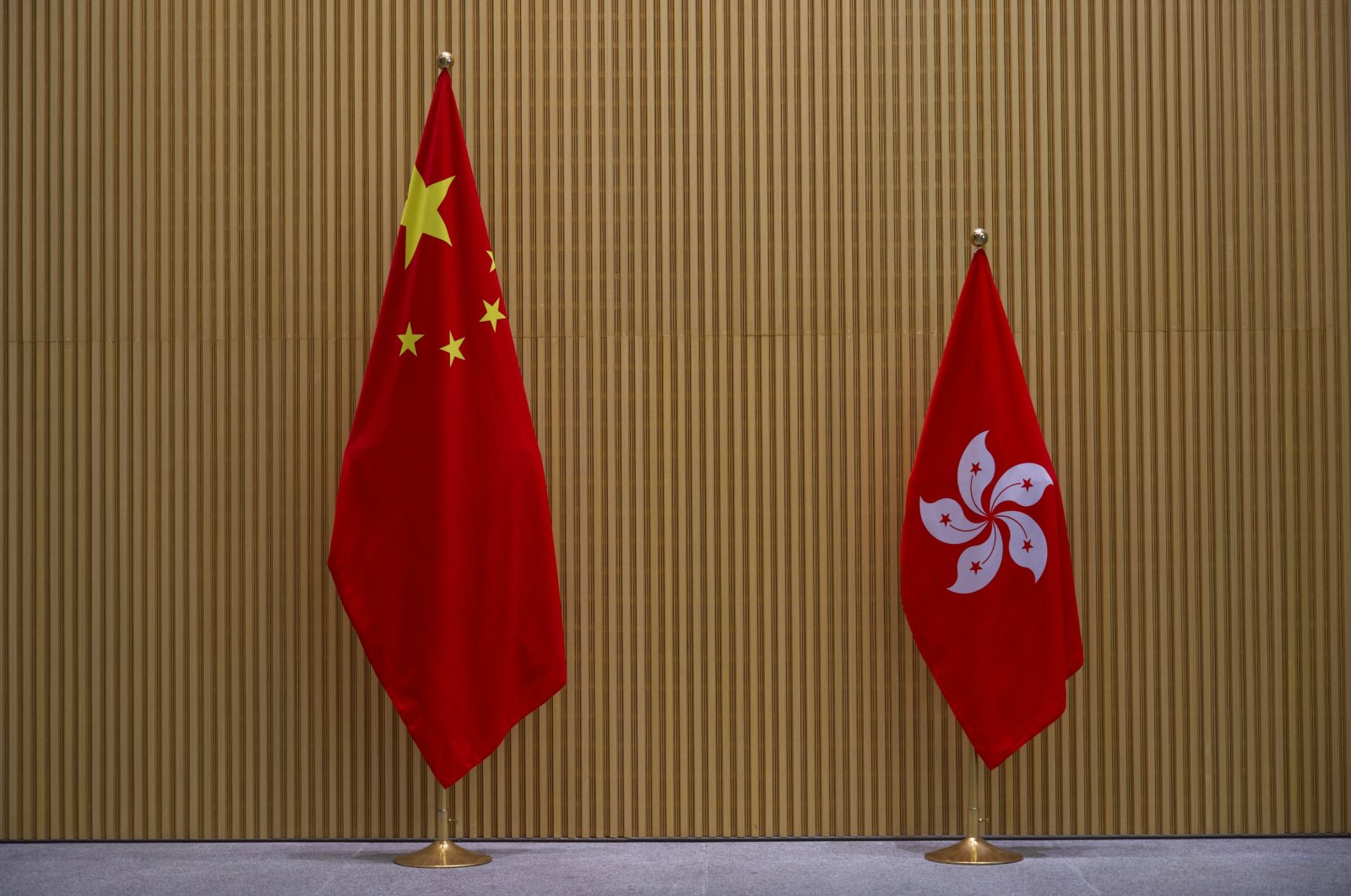 A China national flag (L) and a Hong Kong flag are displayed at central government office in Hong Kong, March 2021. (AP Photo)
