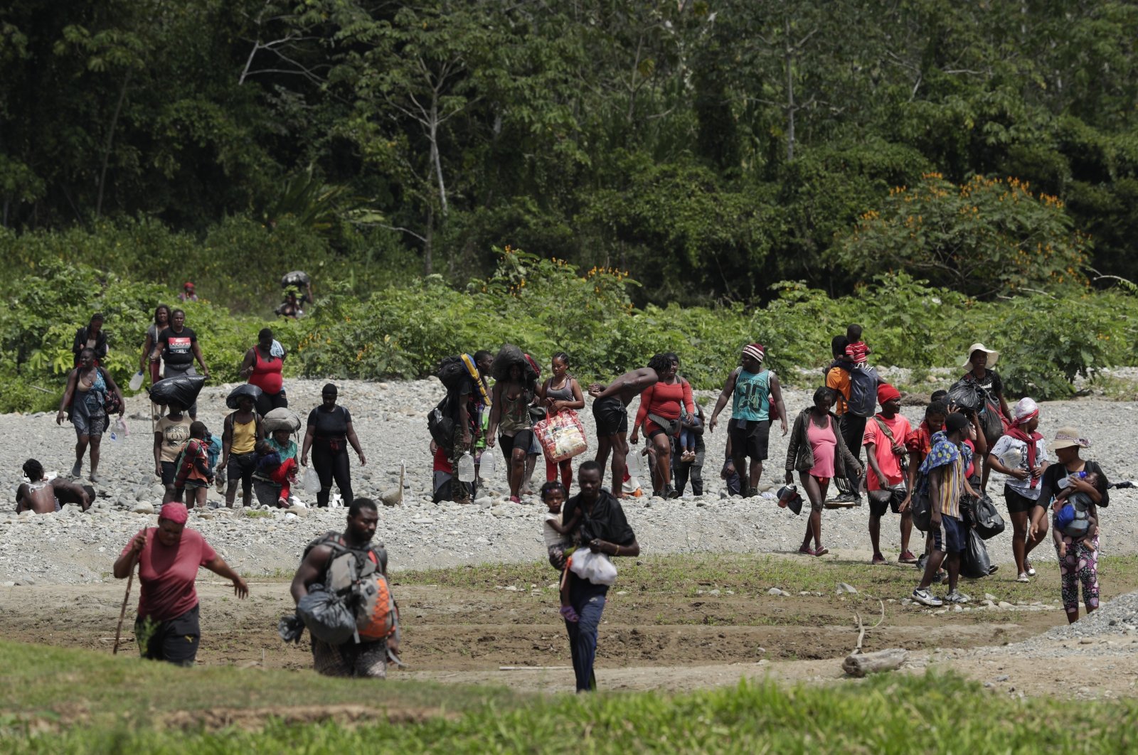 Migrants cross the Tuquesa river after a trip on foot through the jungle to Bajo Chiquito, Darien Province, Panama, on Feb. 10, 2021. (AP Photo)