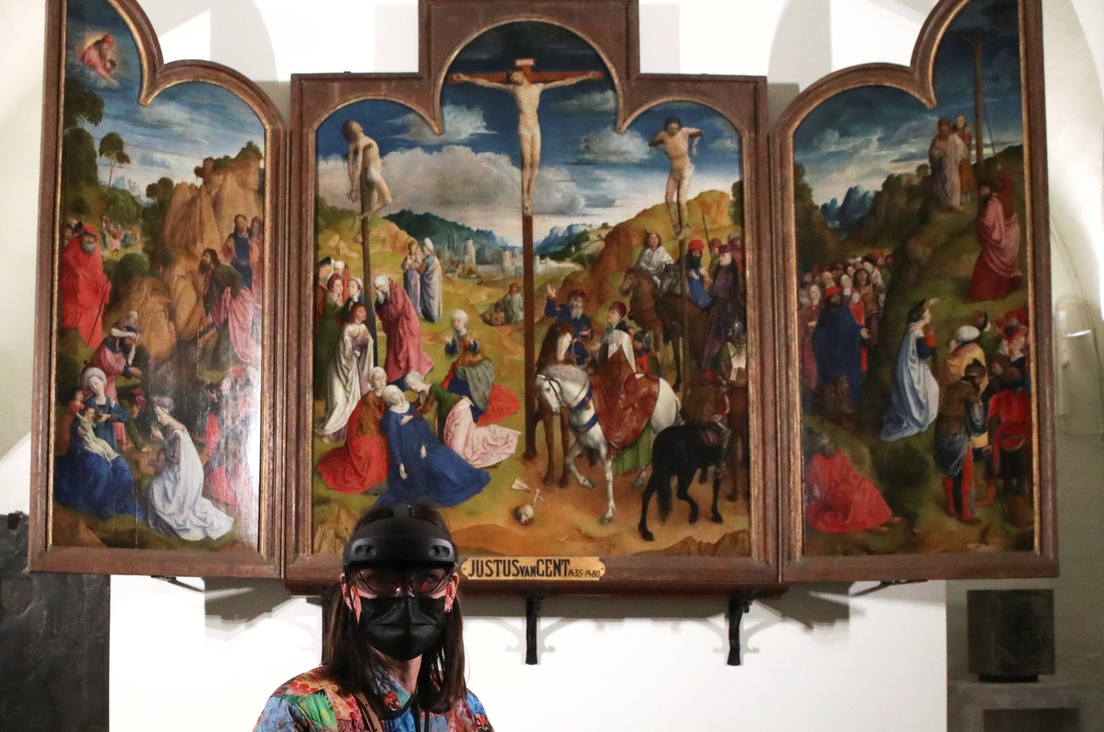 A visitor wears virtual glasses during a visit at St Bavo's Cathedral where Flemish painter Jan Van Eyck's 15th century masterpiece "Ghent Altarpiece" is displayed in Ghent, Belgium, March 26, 2021. (Reuters Photo)