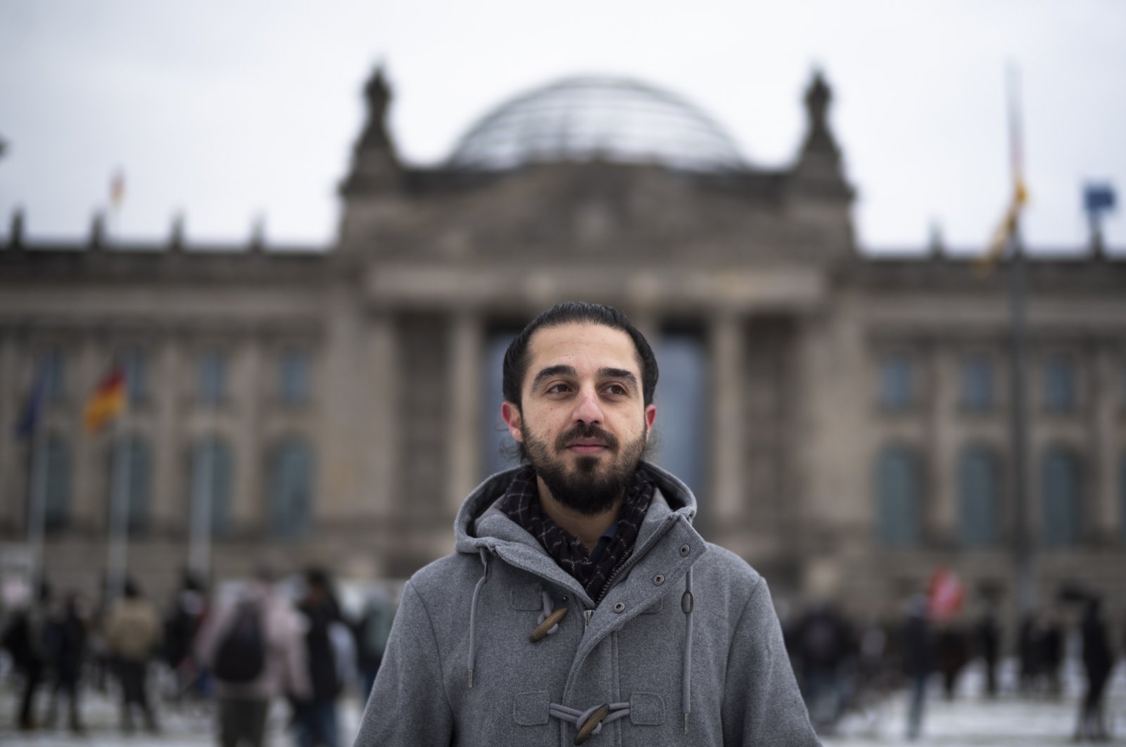 Tareq Alaows, who was running to become a lawmaker at the German parliament Bundestag but withdrew his candidacy, poses in front of the Reichstag building in Berlin, Germany, Feb. 6, 2021. (AP Photo)