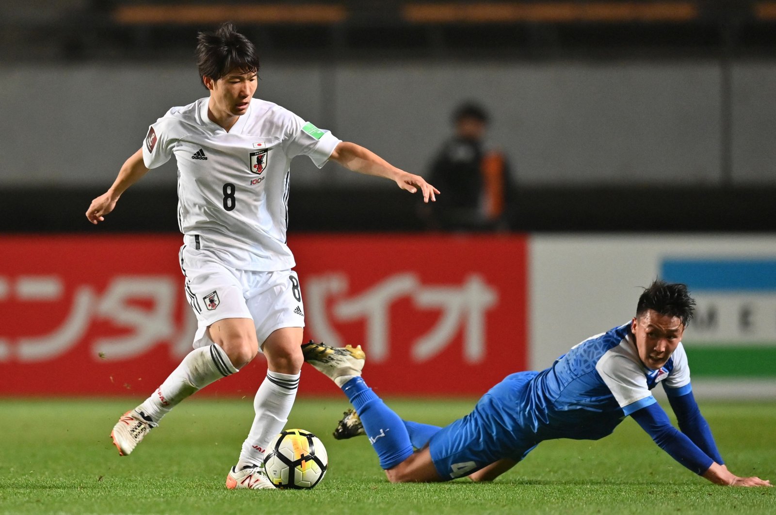 Japan's Sho Inagaki (L) competes for the ball with Mongolia's Amaraa Dulguun during the FIFA World Cup Qatar 2022 Asian zone Group F qualification match at Fuku-ari stadium, Chiba, Japan, March 30, 2021. (AFP Photo)