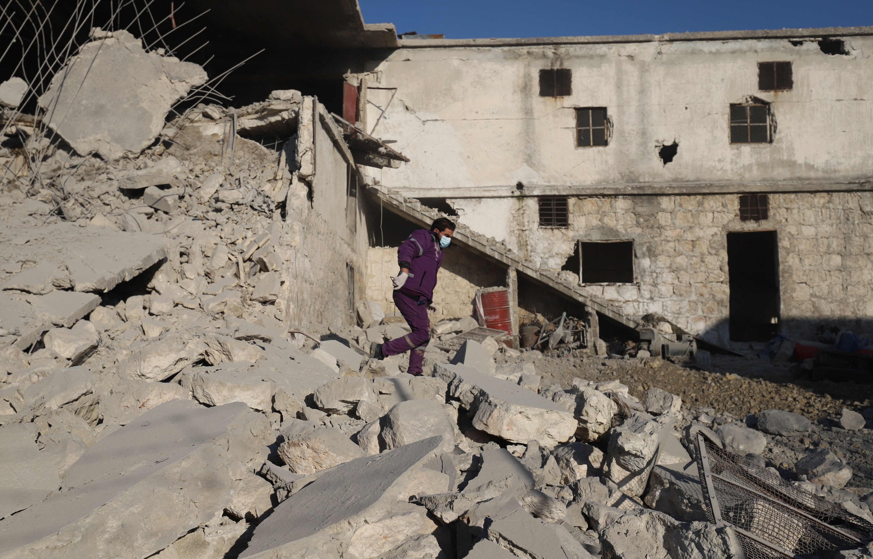 A Syrian man walks amid the rubble of a destroyed building following reported Russian airstrikes on the outskirts of the opposition-held northwestern city of Idlib, Syria, March 29, 2021. (Photo by Abdulaziz Ketaz via AFP)