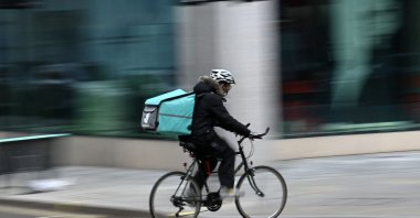 A Deliveroo rider cycles through central London, U.K., March 26, 2021. (AFP Photo)