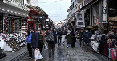 Pedestrians and customers walk past shops in the Mahmutpaşa neighborhood in Istanbul, Turkey, March 22, 2021. (AFP Photo)