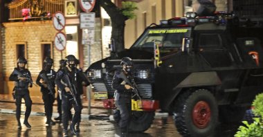 Police officers walk past an armored vehicle at the National Police Headquarters following a suspected militant attack in Jakarta, Indonesia, March 31, 2021. (AP Photo)