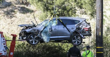 A crane is used to life a vehicle following an accident involving golfer Tiger Woods, in the Rancho Palos Verdes suburb of Los Angeles, California, U.S., Feb. 23, 2021. (AP Photo)