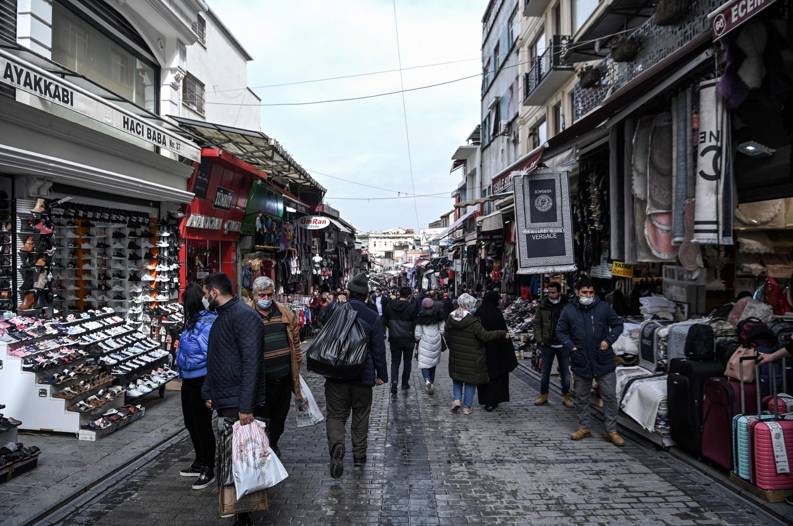 Pedestrians and customers walk past shops in the Mahmutpaşa neighborhood in Istanbul, Turkey, March 22, 2021. (AFP Photo)
