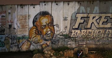 A mural of Fatah leader Marwan Barghouti on a section of Israel's controversial separation wall, near the Israeli Qalandiya checkpoint, between Jerusalem and Ramallah, March 31, 2021. (AFP Photo)