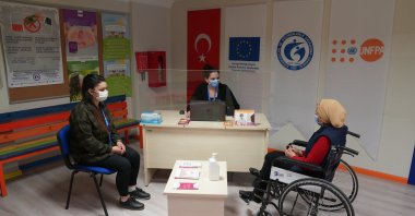 A disabled refugee speaks to a UNFPA worker at an unidentified UNFPA office in Turkey. (UNFPA Photo)