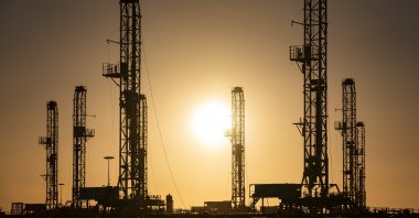 The morning sun rises behind oil rigs sitting in storage at a yard outside of Odessa, Texas, U.S., Feb. 6, 2021. (Odessa American via AP)