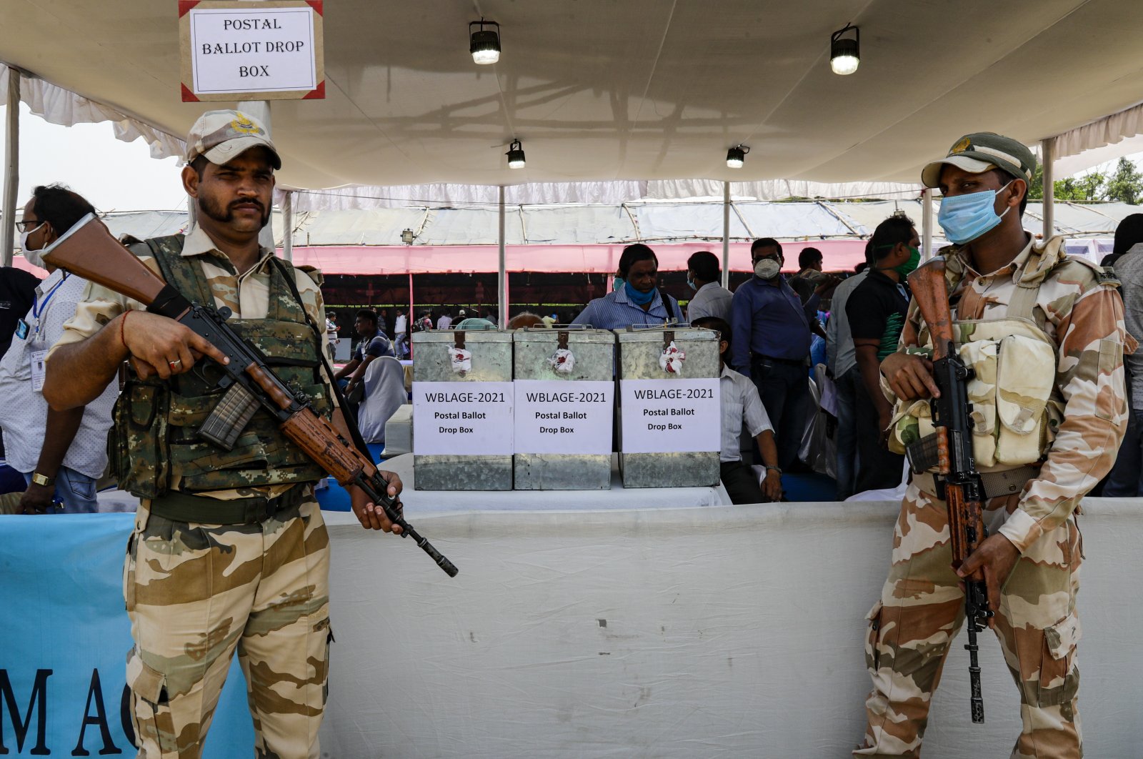 Central Reserve Police Force soldiers stand guard near postal ballot boxes placed for working polling officers ahead of the second phase of West Bengal state elections in Haldia, India, March 31, 2021. (AP Photo)