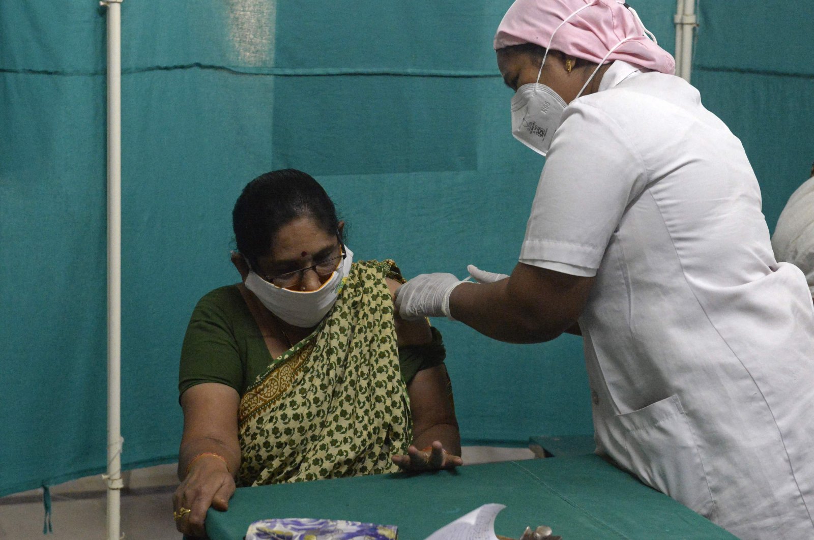 A medical worker inoculates a woman with the dose of Covishield, AstraZeneca-Oxford's COVID-19 vaccine at a government hospital in Hyderabad, India, on April 1, 2021. (AFP)