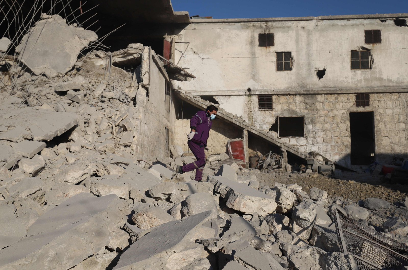 A Syrian man walks amid the rubble of a destroyed building following reported Russian airstrikes on the outskirts of the northwestern city of Idlib, Syria, March 29, 2021. (Photo by Abdulaziz Ketaz via AFP)