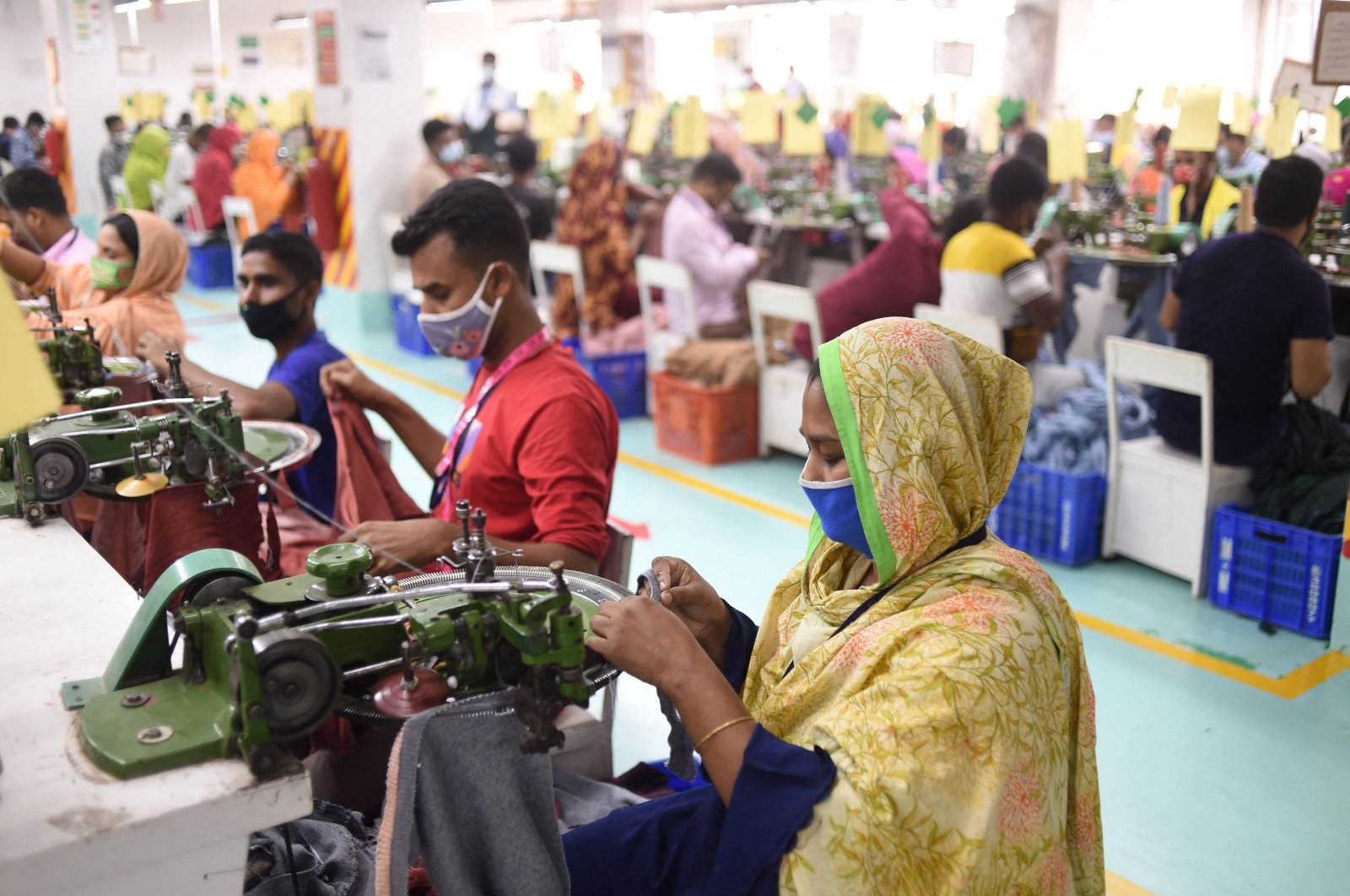 Ruma (R) works in a garment factory in Gazipur, Bangladesh, March 15, 2021. (AFP Photo)