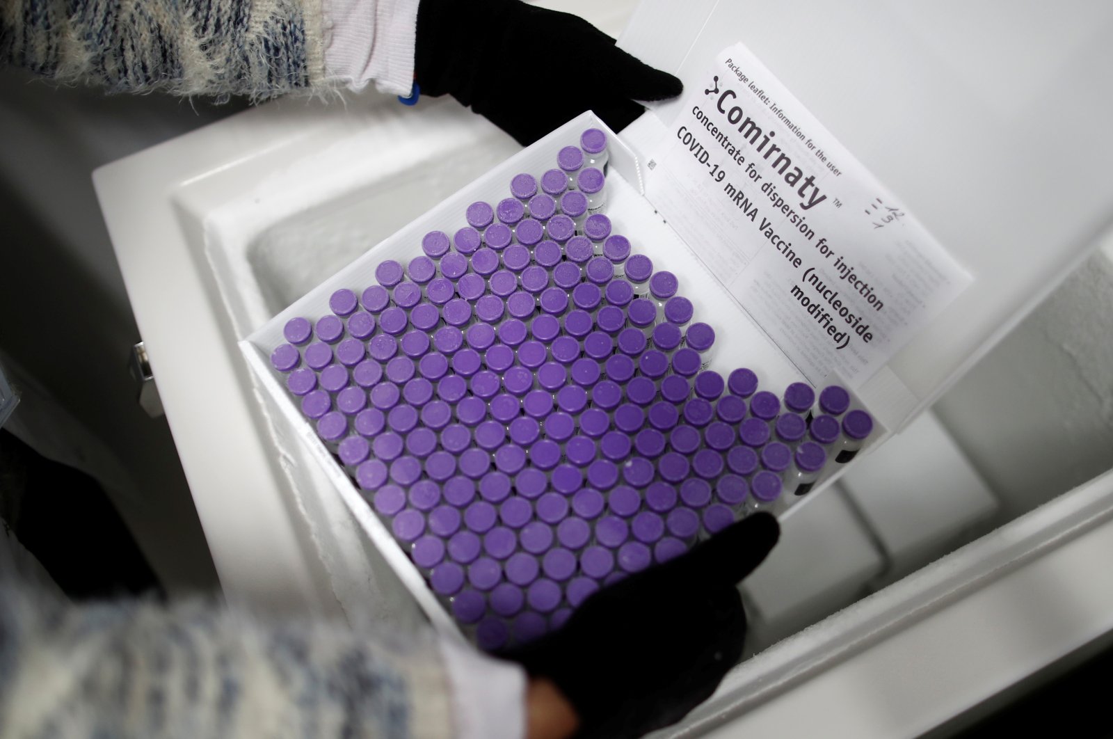 A health worker removes a box containing vials of the "Comirnaty" Pfizer-BioNTech COVID-19 vaccine at an ultra low temperature at the South Ile-de-France Hospital Group in Melun, near Paris, France, March 26, 2021. (Reuters Photo)